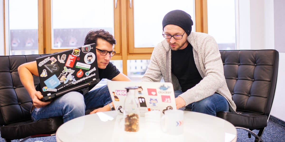 Entwickler arbeiten gemeinsam auf Sofa