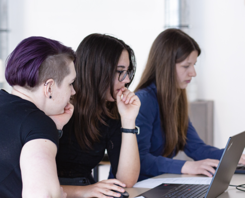 Tutorin Anna Klingauf von Micromata mit Teilnehmerinnen von Girls Go Informatics im April 2024