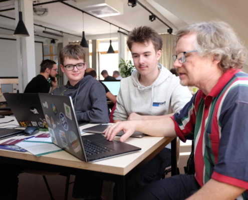 Michael erklärt zwei Kollegen die Spielregeln des Open Source Friday 2025 bei Micromata