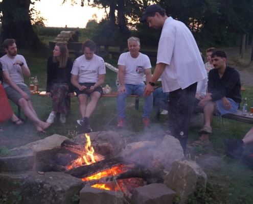 Micromata-Sommerfest 2025 auf Gut Waitzrodt: Menschen entspannen am Lagerfeuer