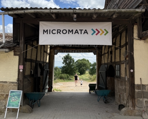 Micromata-Sommerfest 2025 auf Gut Waitzrodt: Fachwerkdurchgang mit Micromata-Banner