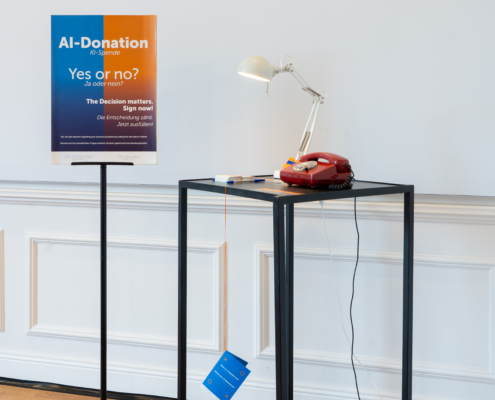 Stand mit Mikrofon und Informationsschild für KI-Spendenaktion