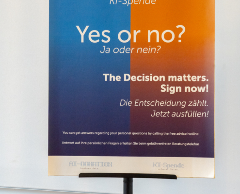 Infotafel zur KI-Spende im Stil eines Organspendeausweises, mit der Frage "Ja oder nein?"