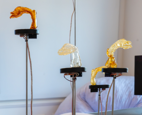 Kreative LED-Kunstinstallation mit leuchtenden, geschwungenen Skulpturen auf Ständern.