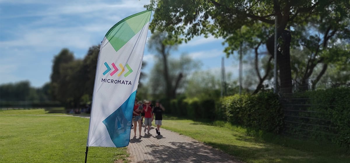 Micromata-Flagge im Park mit Gruppe von Menschen