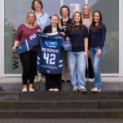 Gruppenfoto: Kapitänin der Kassel Huskies Ladies, Natalie Klemmer, übergibt Micromata unser Sponsoren-Trikot